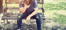 worried man sitting on a bench 1150 339